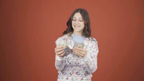 Young-woman-counting-money-looking-at-camera.